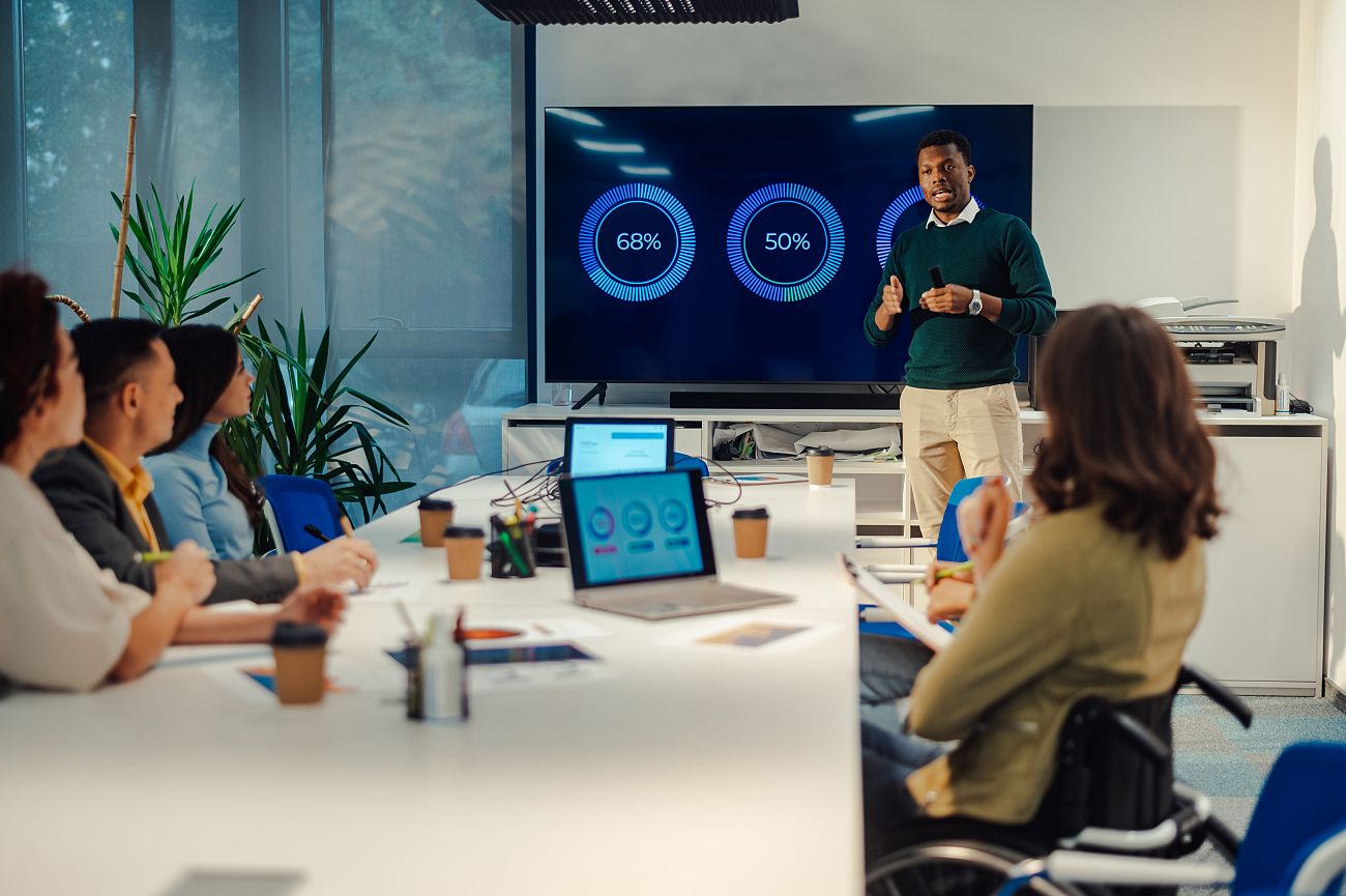 Team in a conference room watching a presentation with data on display